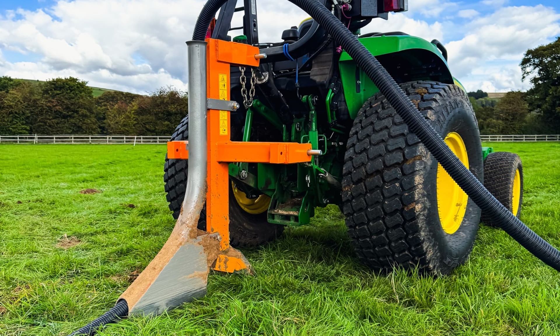 Tractor mole ploughing hard, compacted ground — the conditions the carbide-tipped mole plough is designed for