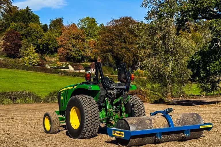 John Deere 4066M compact tractor pulling a Fleming roller across the rotavated East Meon paddock on a sunny autumn day