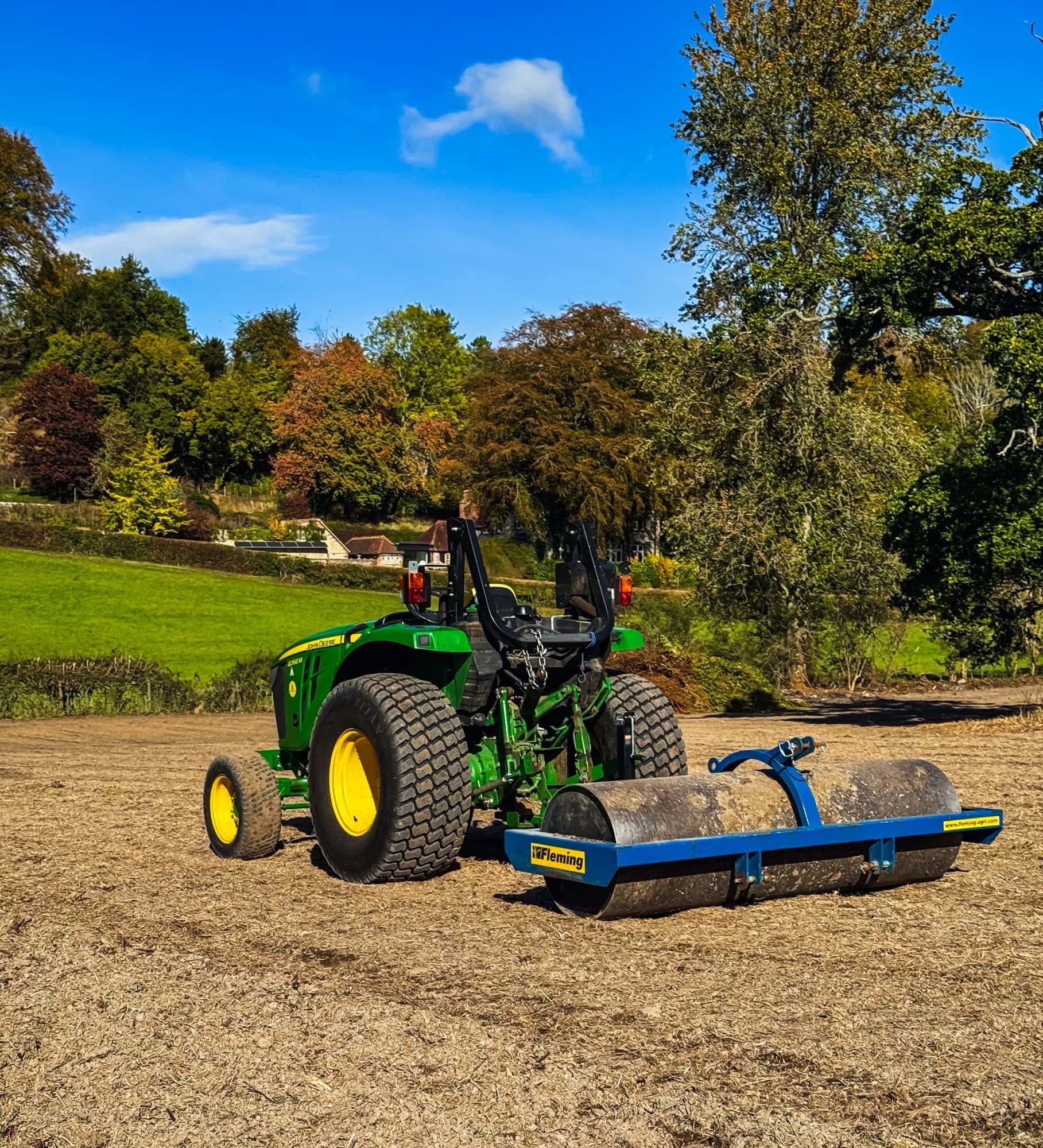 John Deere 4066M compact tractor pulling a Fleming roller across the rotavated East Meon paddock on a sunny autumn day