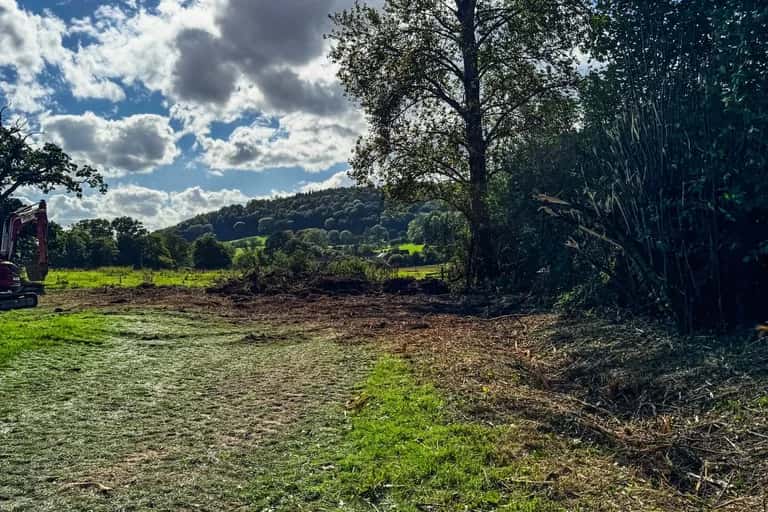 Stump holes filled and tracked level across an East Meon paddock, with the Meon valley beyond